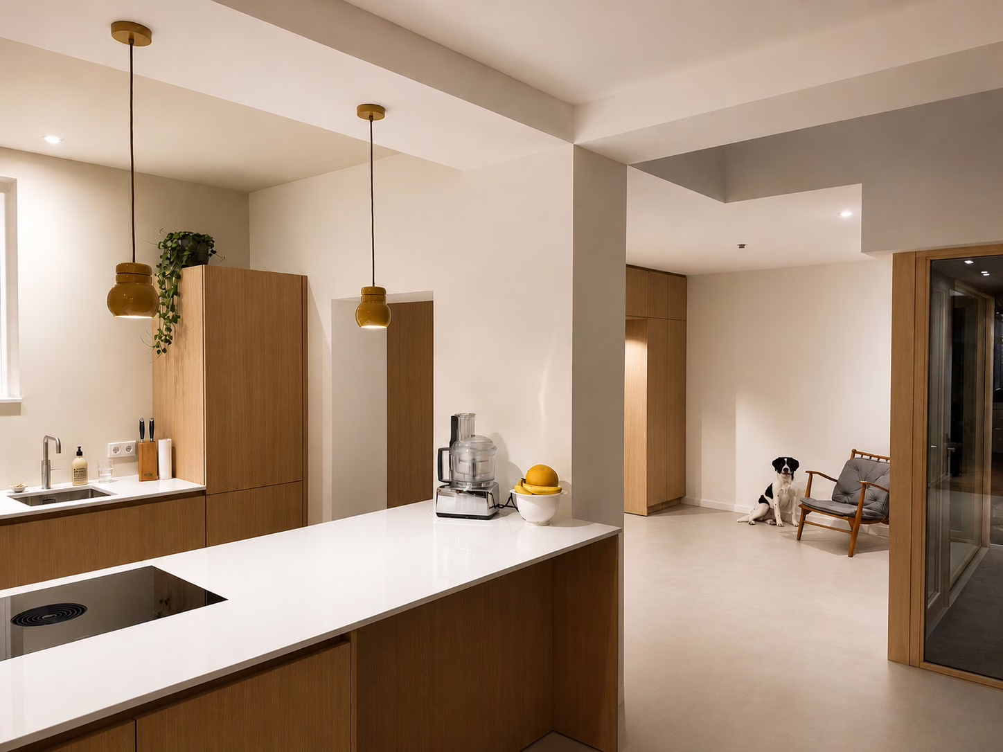Warme Minimal Sand gietvloer Eindhoven in kleur Hekla — open keuken met eiken maatwerk en doorkijk naar de hal.