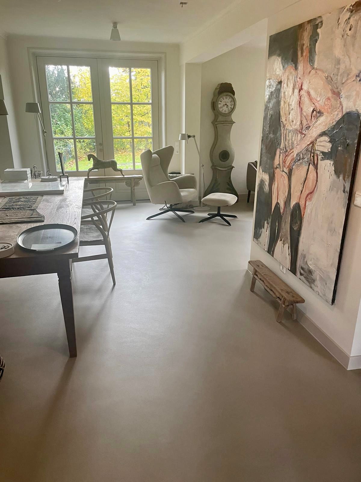 Lavasteen gietvloer Bergharen in Zandsteen Creme, doorlopend van eettafel tot woonkamer met groot schilderij