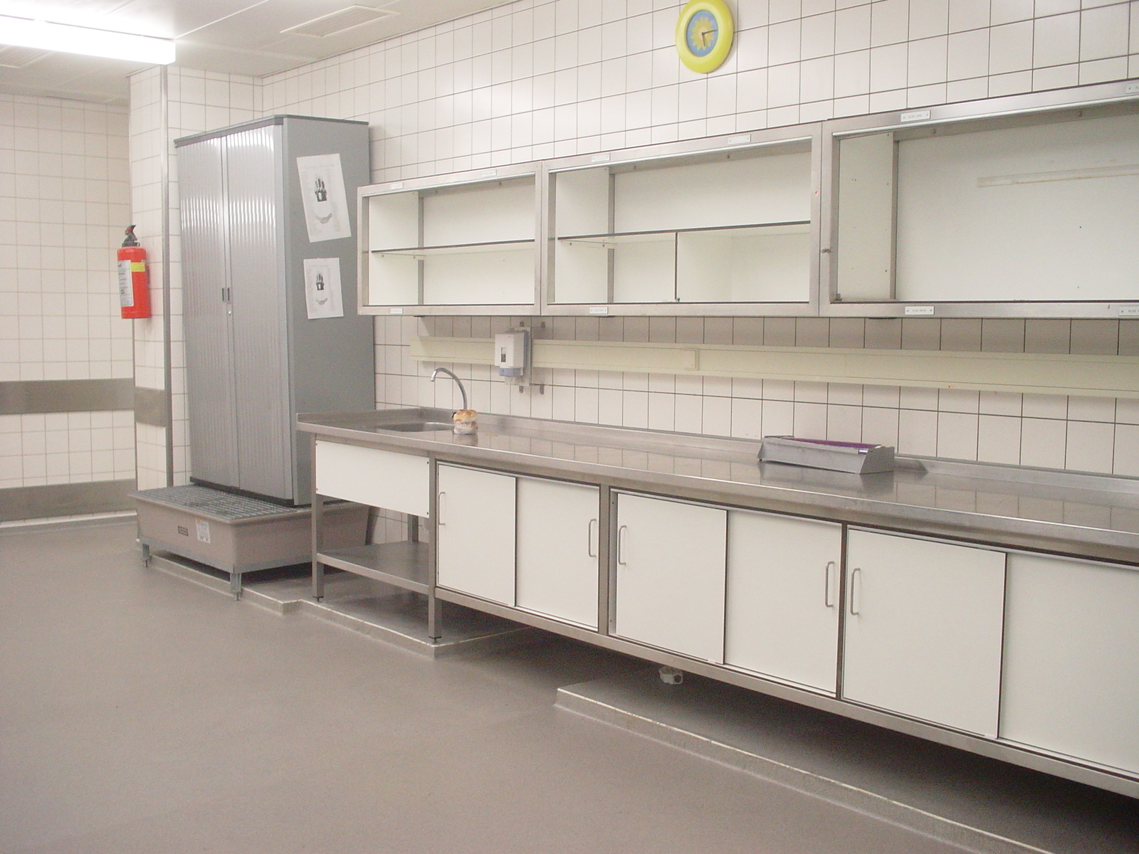 Epoxy gietvloer in een professionele keuken Professionele keuken met roestvrijstalen werkbladen en een naadloze grijze epoxy gietvloer