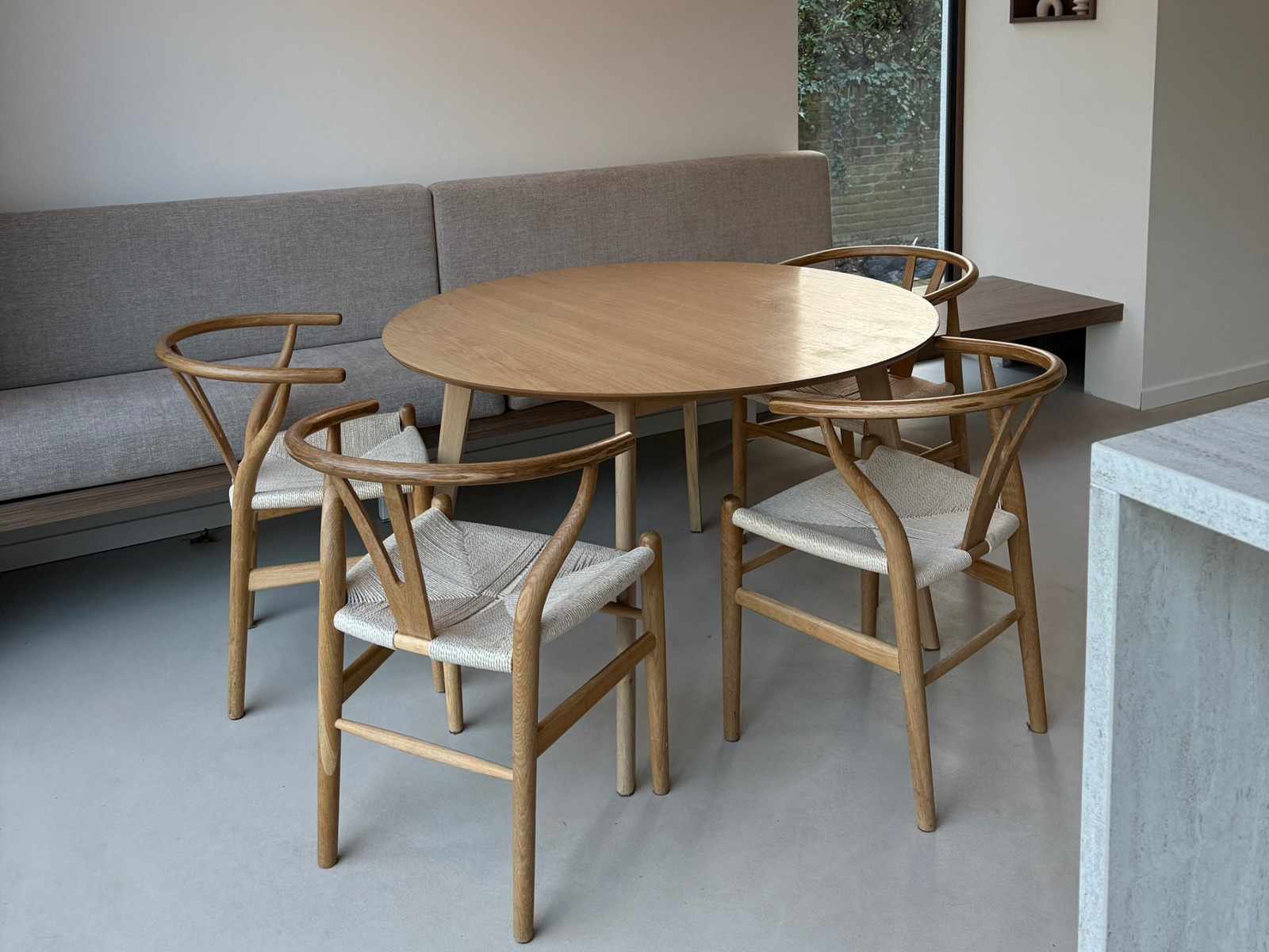 Minimal Sand gietvloer in Saint Louis, eethoek Wijchen Japandi eethoek in Wijchen met een ronde eikenhouten tafel op een Minimal Sand gietvloer in de kleur Saint Louis